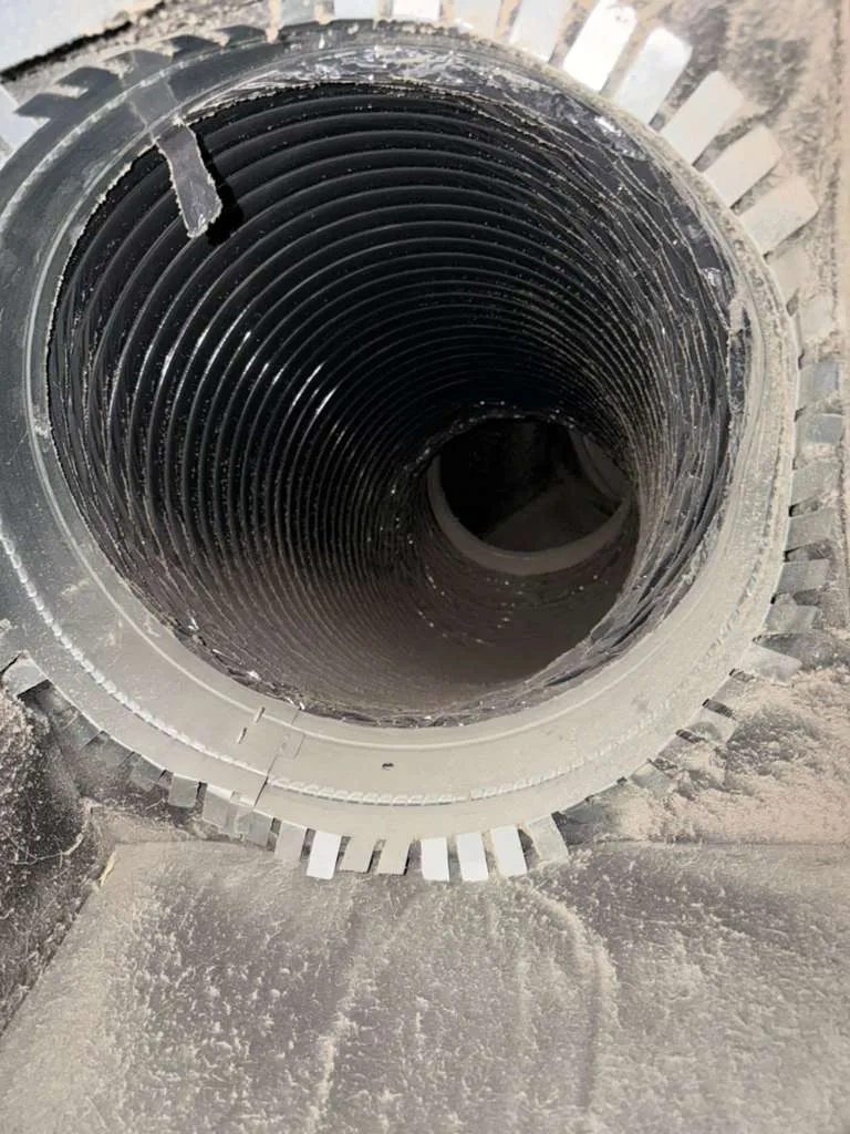 Technician inspecting a dusty air duct vent, illustrating the need for regular air duct cleaning and maintenance